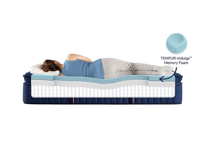 a woman on a cutout of the mattress to show how the tempur-indulge memory foam contours the body