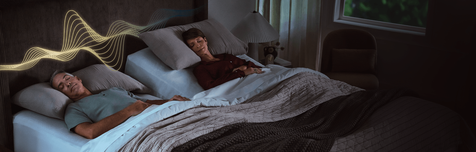 Two people on an split king mattress with one side raised