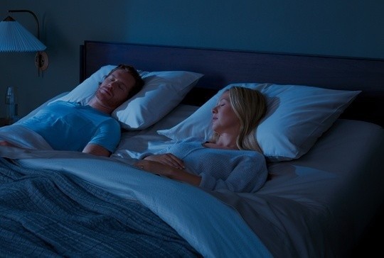 Couple sleeping in bed with mattress slightly lifted